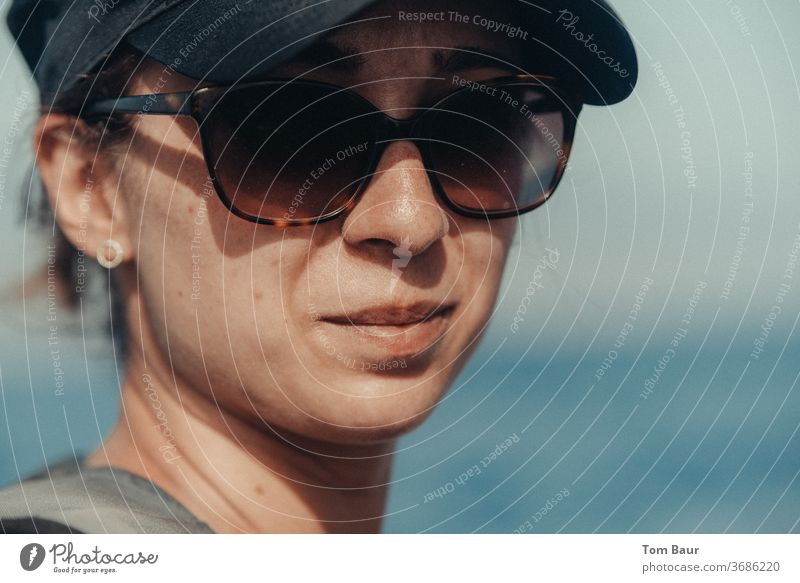 Portrait einer Frau mir Basecap und Sonnenbrille Porträt basecap sonnenbrille mütze Blick in die Kamera Mensch Erwachsene Farbfoto Mütze Außenaufnahme feminin