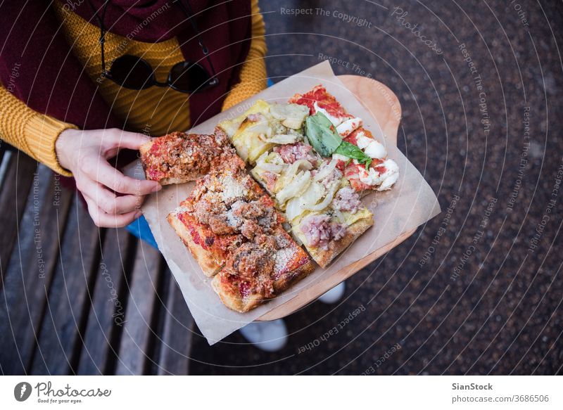 Draufsicht auf eine Frau, die mit der Hand Pizza holt Lebensmittel Italienisch Käse Tomate Straße Mozzarella Mahlzeit Nahaufnahme Hände Halt halten Top Ansicht