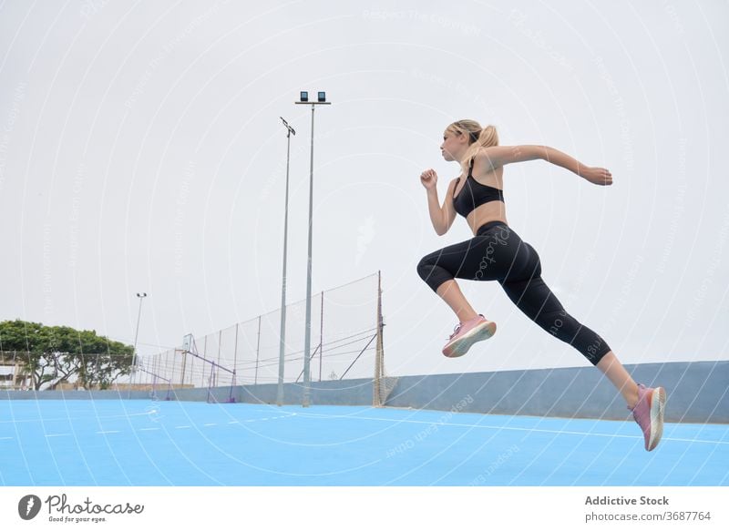 Schlanke Sportlerin springt auf Sportplatz Frau springen laufen Training Übung Fitness Athlet schlank jung modern Wellness Wohlbefinden Gesundheit Lifestyle