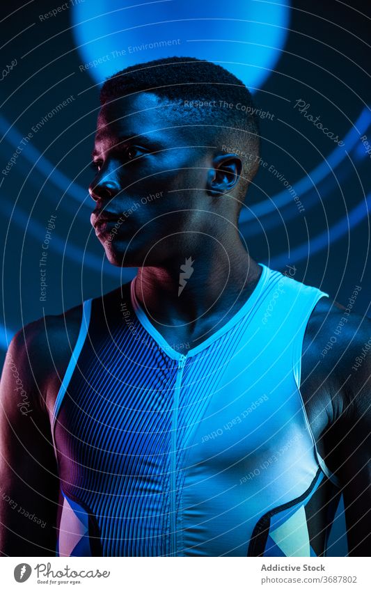 Starker ethnischer Sportler schaut weg Athlet selbstbewusst ernst Konzentration brutal wettbewerbsfähig Bestimmen Sie Mann neonfarbig Herausforderung blau aktiv