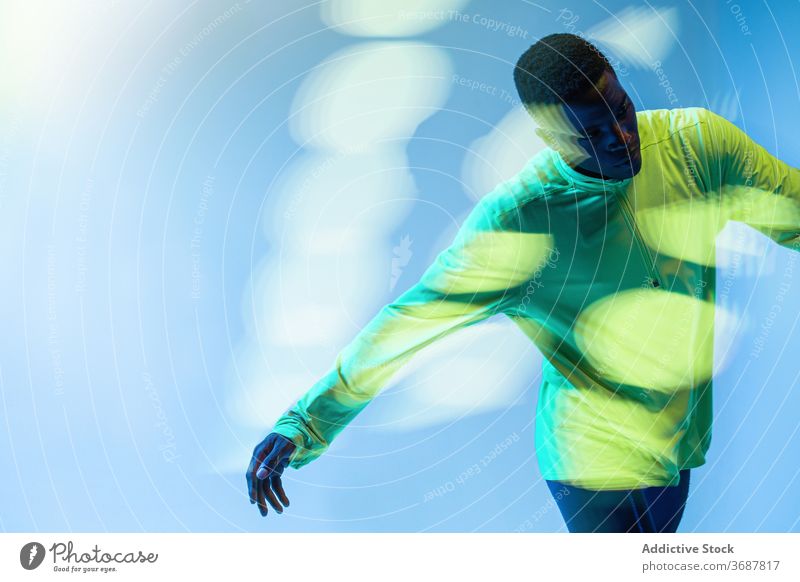 Sportler läuft im Studio Läufer Athlet muskulös Mann Bestimmen Sie selbstbewusst aktiv physisch neonfarbig jung schwarz Afroamerikaner ethnisch männlich
