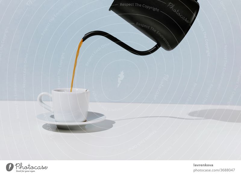 Kaffee gegossen aus schwarzer Metallkanne weiße Tasse, selektiver Fokus Café Aroma Getränk Frühstück Koffein trinken Espresso Lebensmittel Hand heiß Morgen