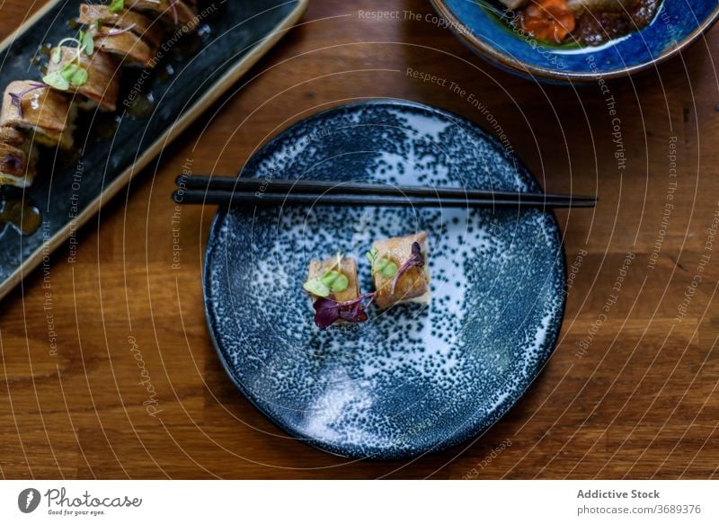 Leckeres Sushi auf Teller mit Stäbchen serviert Lachs rollen Essstäbchen dienen Restaurant appetitlich Asiatische Küche frisch Bambus Reis geschmackvoll