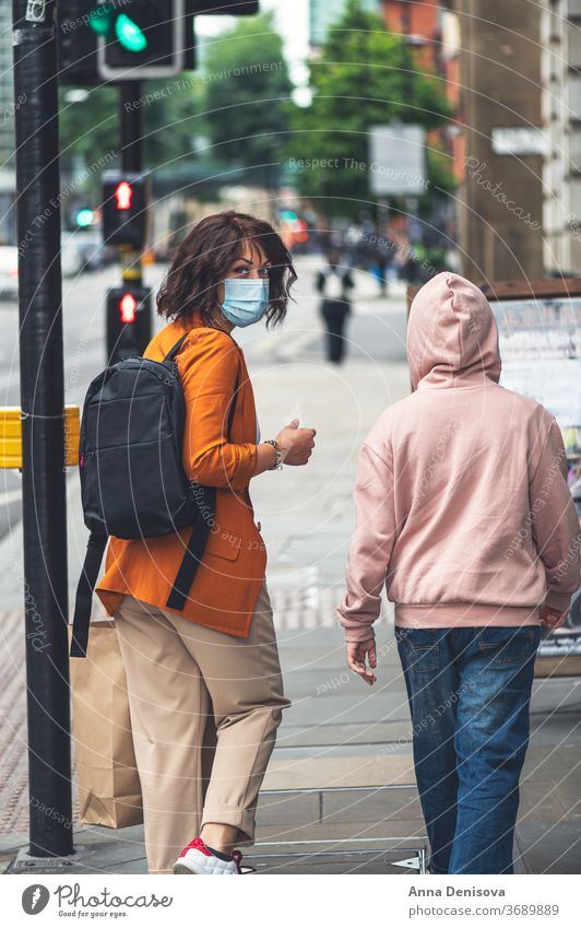 Mutter und Tochter mit Gesichtsmaske gehen einkaufen Großbritannien neue Normale Manchester England Mädchen deckend Schutz Geschäfte Anzeige Fenster Sperrung
