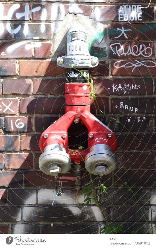 Wasserspender Hydrant Fassade Wand Backstein rot Mauer alt Graffiti Gebäude Haus