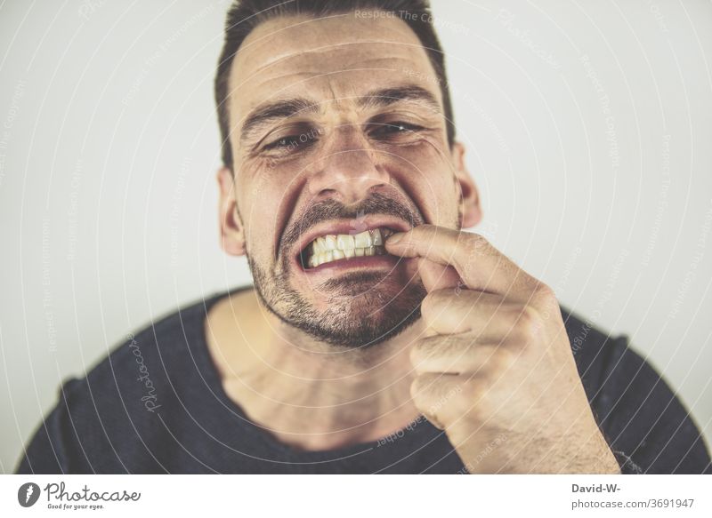 etwas zwischen den Zähnen haben Essensreste Zahnschmerzen Spiegel gucken Spiegelbild entfernen Finger Mund