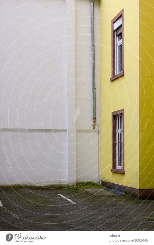 gelbes Haus im Winkel Wand weiß Fenster braun Straße grau Einteilung Abflußrohr Ecke Licht Höhe Länge Scheibe Tragwerk Trennung Innenraum Außenraum Boden Leere