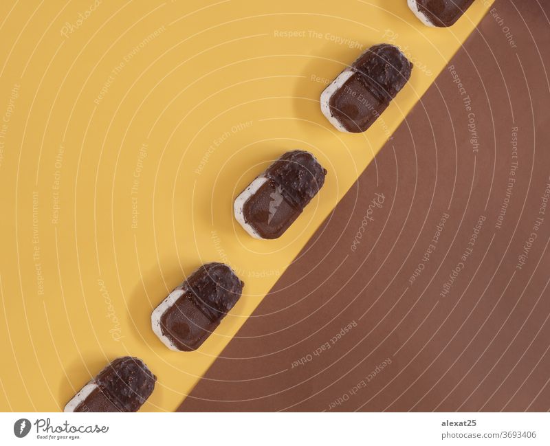 Eiscreme-Muster auf gelbem und braunem Hintergrund Biskuit Schokolade kalt farbenfroh Zapfen Sahne dekorativ lecker Dessert Gewebe Geschmack Lebensmittel