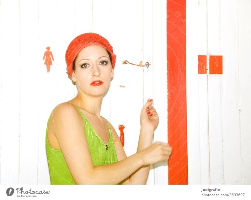 Das Mädchen mit der schönen roten Badekappe und grünem Badeanzug wird vor der Umkleide geblitzt. Eine Sommerliebe. Frau Badebekleidung Badehaube Haut jung