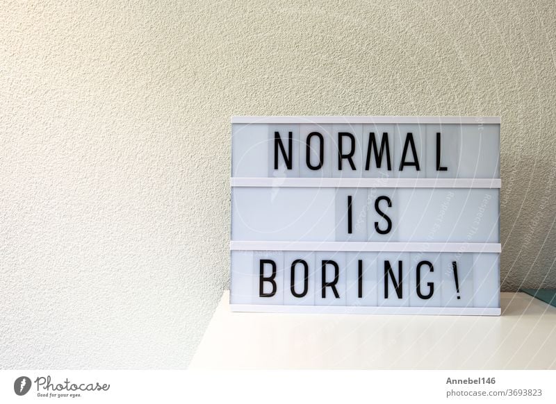 Normal ist langweilig geschrieben in Light box home decoration, Motivationsschild retro home, Platz für Text normal Phrase weiß Wort Konzept Hintergrund