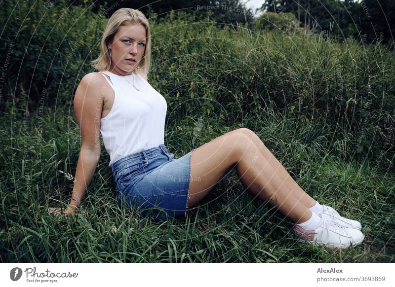 Portrait einer jungen Frau in tiefen Gras junge Frau blond Lächeln Schmuck schön langhaarig Landschaft gebräunt selbstbewußt Sommer natürlich weiblich verliebt