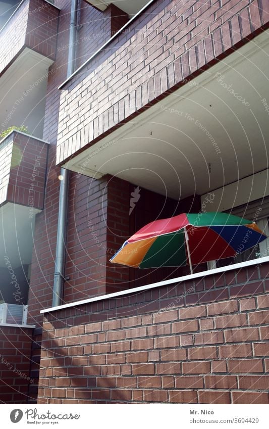 Farbkombination oder Nachbarschaften Sonnenschirm Balkon Haus Architektur Gebäude Fassade Hochhaus Wohnung Häusliches Leben Klinkerfassade Fallrohr bunt