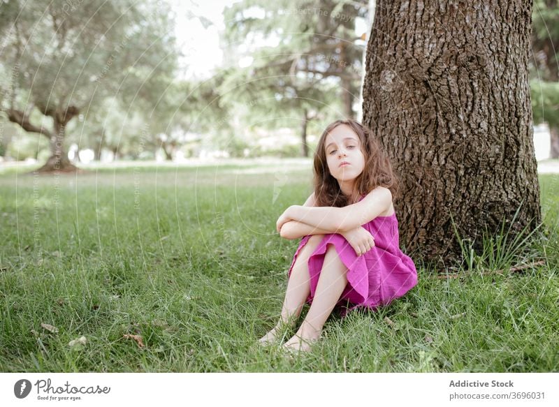 Kleines Mädchen sitzt unter Baum im Park ruhen Natur sitzen sich[Akk] entspannen ruhig Windstille Kind Sommer Gras Lifestyle Harmonie Rasen Gelassenheit