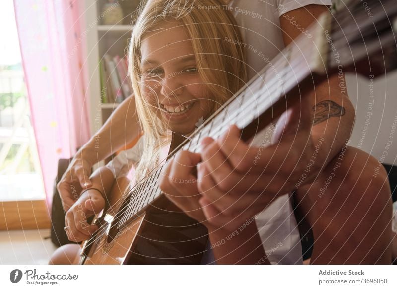 Lächelndes Mädchen und eine Frau spielen Gitarre in einem Haus Musik Lehrer Bildung Lernen Schüler Lektion Spielen Instrument Musiker Leistung Pupille lernen