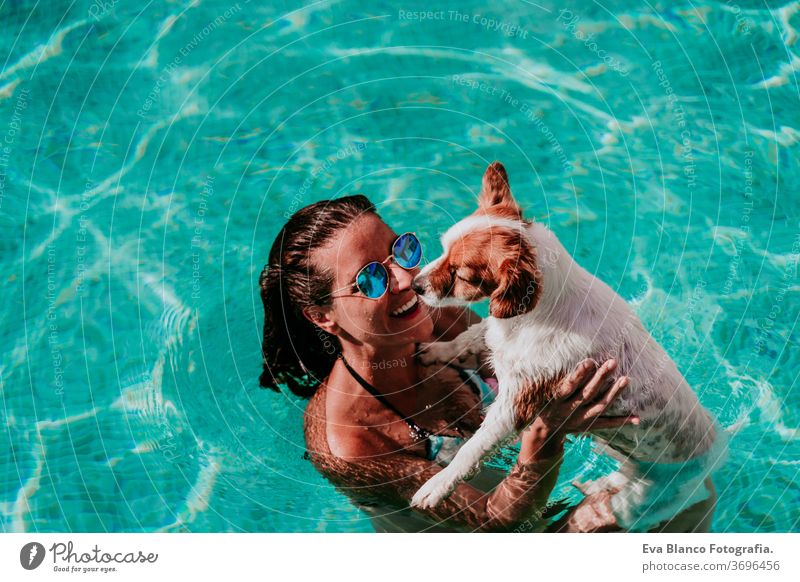 glückliche junge Frau und Hund in einem Schwimmbad, die Spaß haben. Sommerzeit Blauwasser Liebe jack russell Hut Zusammensein Zusammengehörigkeitsgefühl Kuss