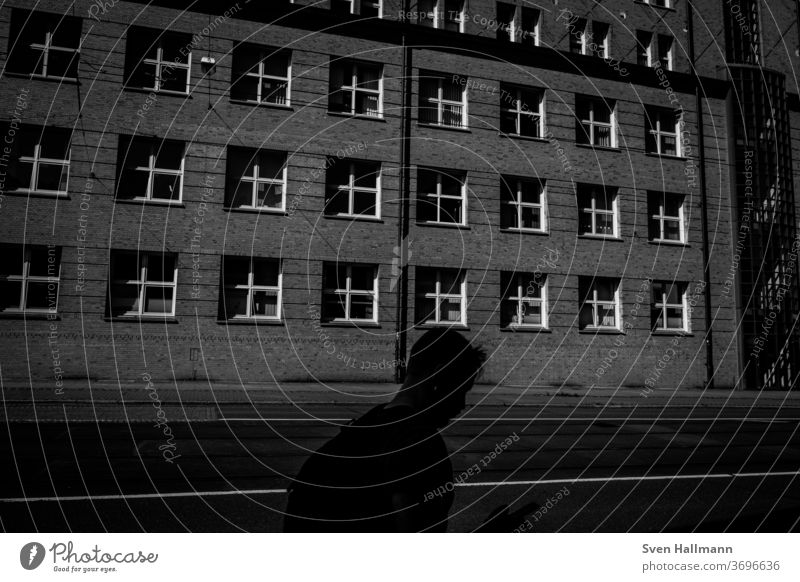 Schatten eines Menschen vor einem Haus Außenaufnahme Licht Großstadt modern Architektur Wand Stadt Wege & Pfade Straßenverkehr Aktivität Unschärfe Bewegung