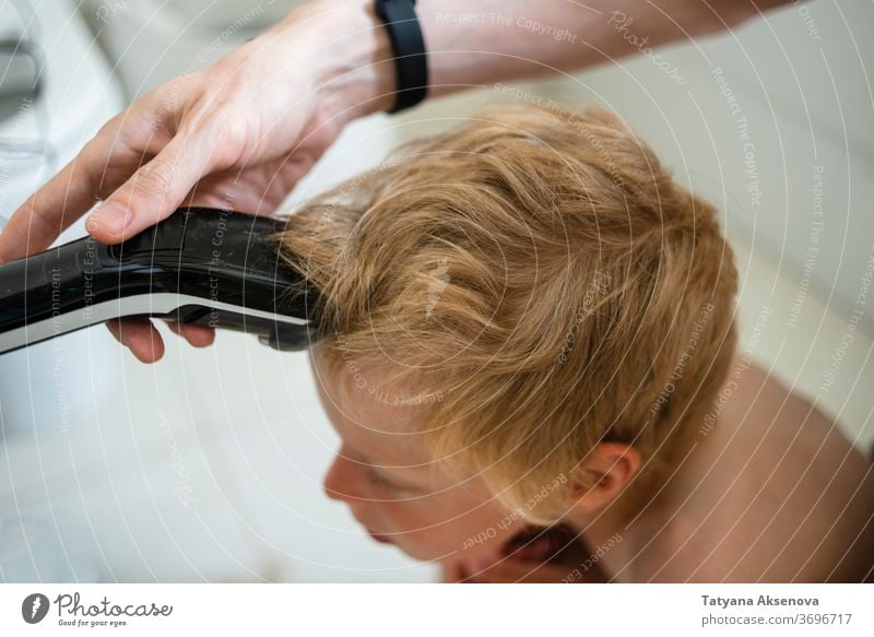 Vater schneidet dem Sohn zu Hause die Haare Behaarung Haarschnitt heimwärts Frisur Kind Pflege Maschine Bad Familie Hand geschnitten Friseur Mann Trimmer