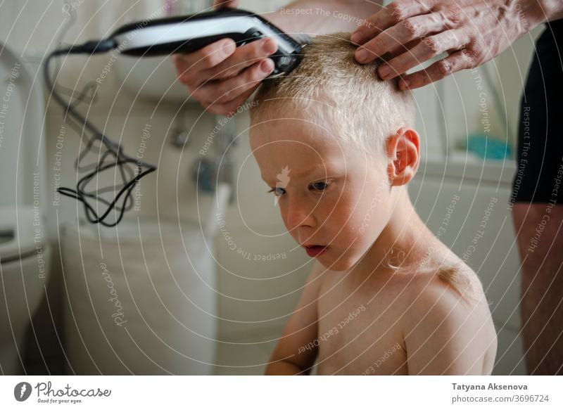 Vater schneidet dem Sohn zu Hause die Haare Behaarung Haarschnitt heimwärts Frisur Kind Pflege Maschine Bad Familie Hand geschnitten Friseur Mann Trimmer