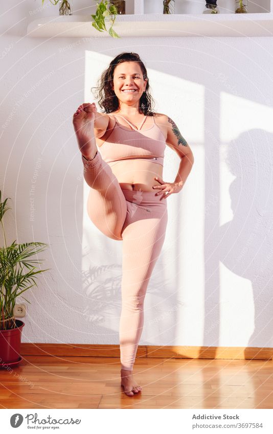 Lächelnde Frau macht Yoga in Stehende Hand zu Fuß Pose üben hasta padangusthasana Hand-zu-Fuß-Pose Sportbekleidung mollig heiter Erholung heimwärts Glück