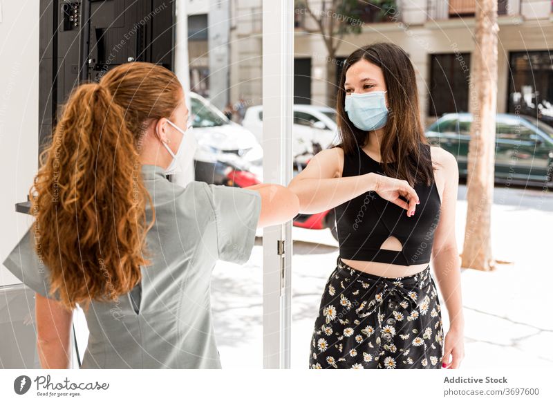 Fachkraft eines Wellness-Salons begrüßt Kunden mit Geste während der Coronavirus-Pandemie Gruß gestikulieren behüten verhindern neue Normale Mundschutz Frauen