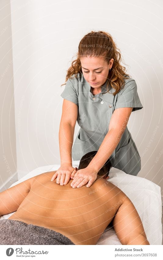 Masseurin massiert den Rücken eines männlichen Patienten Massage Leckerbissen professionell Verfahren Pflege geduldig Therapie Presse Wellness Klient Salon