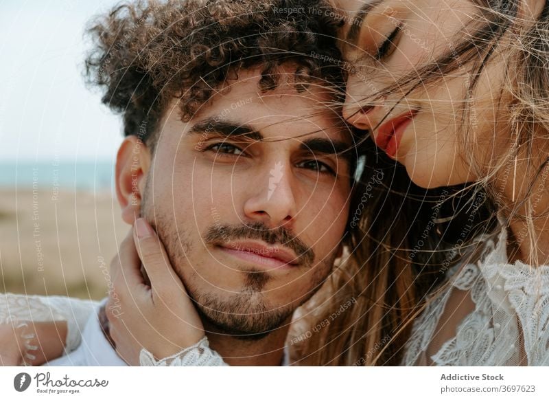 Glückliches frisch verheiratetes Paar umarmt am Strand romantisch Jungvermählter kuscheln sanft genießen Zusammensein Partnerschaft Liebe Umarmen Heirat Angebot