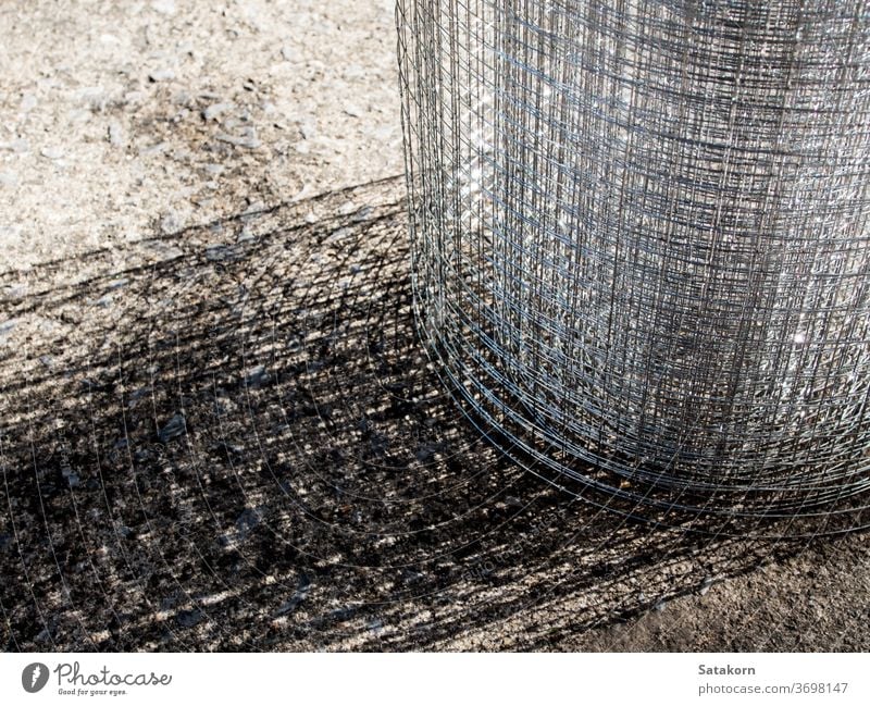 Loses, glänzendes, dünnes Drahtgitter rollen Gitter Metall Stahl lose ineinander greifen Käfig Netz Raster Konstruktion Textur metallisch grau industriell