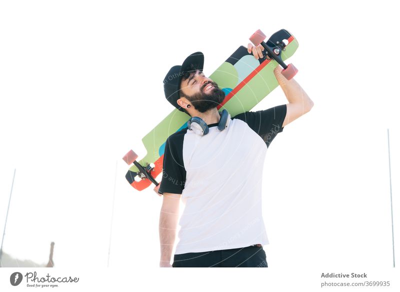 Lächelnder Mann mit Longboard auf der Straße Hipster Wochenende Großstadt Skater jung Generation sonnig männlich Sommer Freude sich[Akk] entspannen trendy