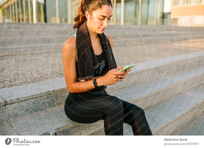 Sportliche Frau mit Smartphone auf der Straße sportlich passen jung modern Apparatur Ohrstöpsel schlank Fitness Mobile Telefon Training Gerät Treppe Athlet