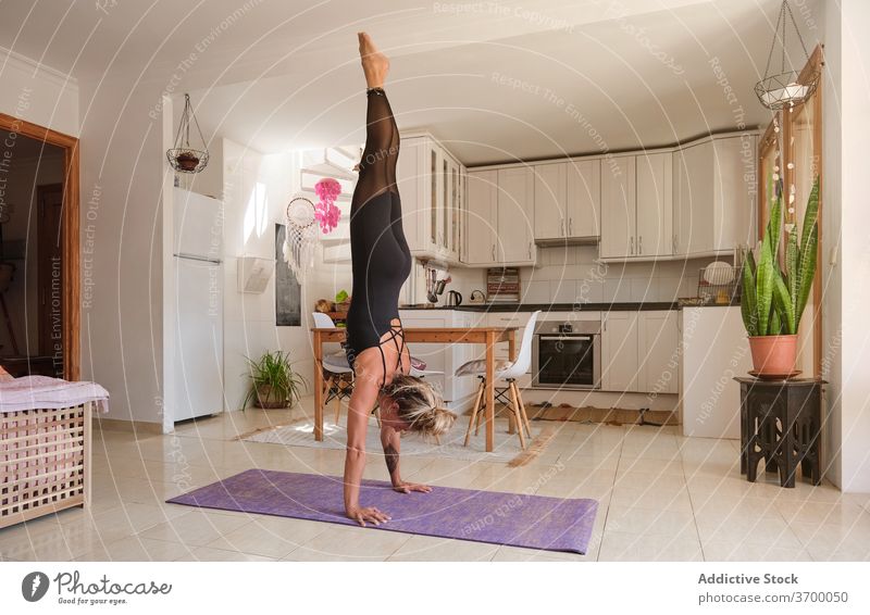 Frau macht die Yoga-Handstände Position in einem Haus Gleichgewicht Genuss trainiert. Freiheit Erholung Routine Einfachheit Spiritualität Achtsamkeit Stärke