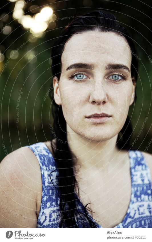 Nahes Portrait einer sommersprossigen Frau mit nassen Haaren in einem See vor Schilf zart Licht sportlich feminin Empathie Gefühle emotional Blick in die Kamera
