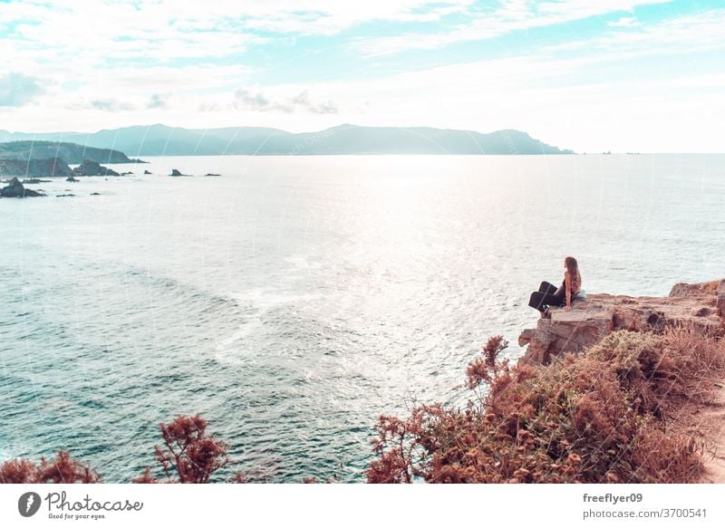 Frau, die den Ozean von einer Klippe aus betrachtet betrachtend wandern Textfreiraum Landschaft Meereslandschaft Loiba Galicia Klippen Steine felsig MEER
