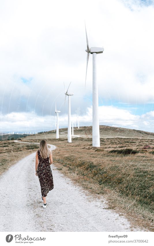 Frau geht an einer Windkraftanlage vorbei laufen Person jung Turbine Öko Energie Elektrizität Ökologie Textfreiraum Himmel Galicia Spanien Sauberkeit Bauernhof