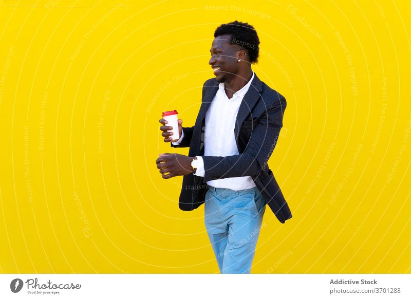 Lächelnder ethnischer Geschäftsmann in der Stadt Imbissbude Kaffee Mann Großstadt heiter Unternehmer zum Mitnehmen gut gekleidet Straße männlich Afroamerikaner