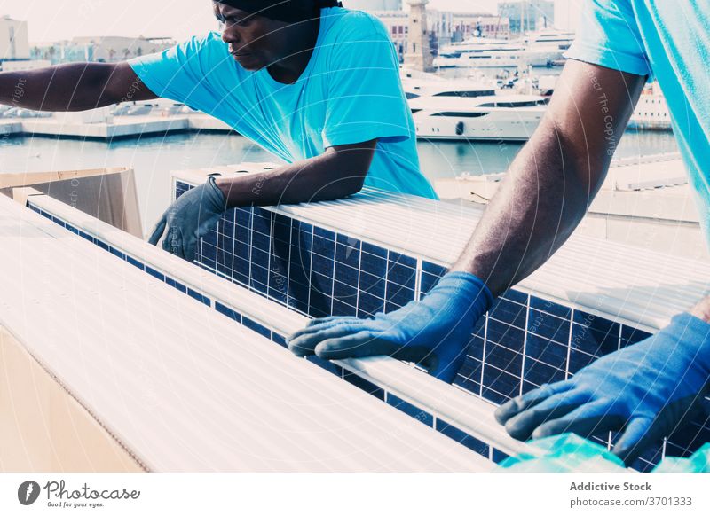 Schwarze Männer mit Solarbatterien solar Panel installieren Batterie Zusammensein Arbeit alternativ Energie Ressource ethnisch schwarz Afroamerikaner