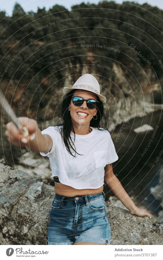 Lächelnde Frau nimmt Selfie während der Reise Reisender Selfie-Stick Hügel Berge u. Gebirge Tourist fotografieren sorgenfrei Inhalt Abenteuer Gedächtnis Moment