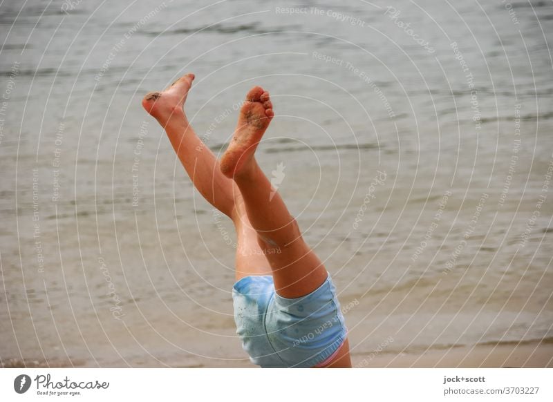 Gymnastik am Strand Beine Handstand Jugendliche Fuß Körperbeherrschung beweglich Bewegung Turnen Binde- und Stützgewebe Stabilität Meer Kurze Hose körperübung