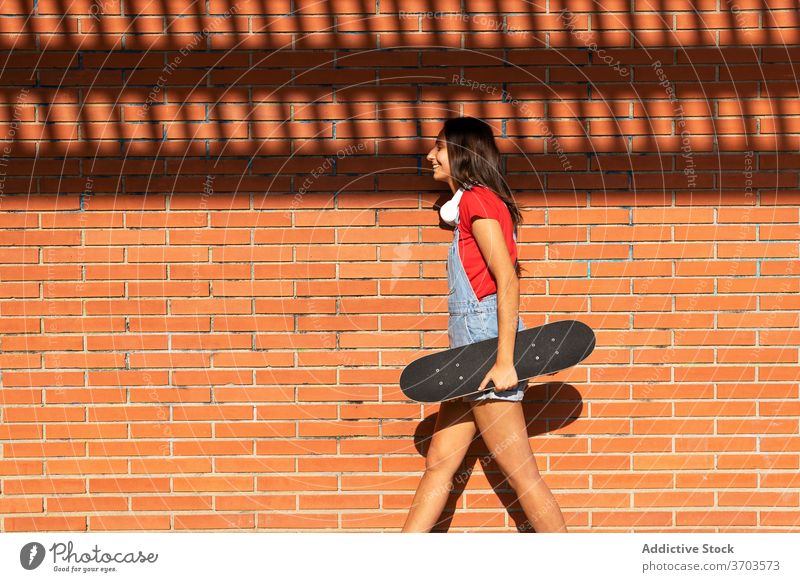 Fröhliche Frau mit Skateboard in der Stadt tausendjährig Spaß haben Skater heiter Lachen lustig Großstadt urban Generation jung Freude Lächeln trendy sorgenfrei