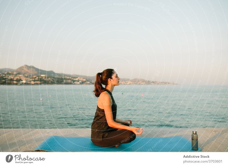 Flexible Frau meditiert in Lotus-Pose meditieren Yoga Sonnenuntergang MEER Achtsamkeit Unterlage Harmonie sich[Akk] entspannen Meereslandschaft Asana ruhig