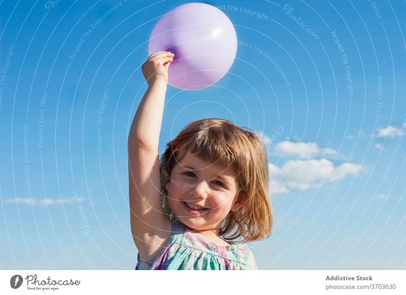 Inhalt Mädchen mit Luftballon im Sommer Kind Spaß haben Spielzeug Freude Kindheit Lächeln Kleid heiter Feiertag Sommerzeit Blauer Himmel Sonnenschein hell