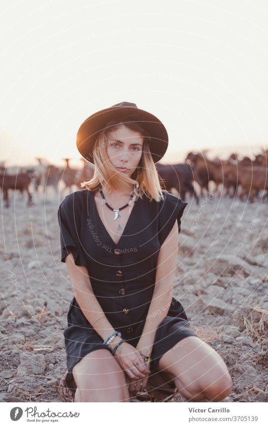 Junge Frau in einem grünen Kleid und einem Hut in einem einsamen Feld auf dem Land mit Ziegen im Hintergrund Landschaft Freiheitsfrau Wasser Erwachsener lebend