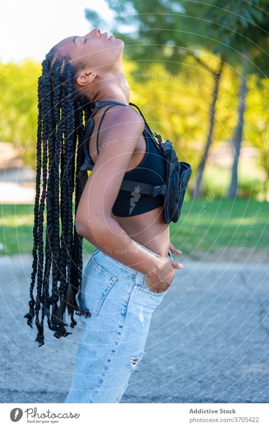 Sinnliche ethnische Frau in trendigem Outfit steht im Park Stil trendy jung Geflecht Mode Streetstyle Hipster Afroamerikaner urban schwarz tausendjährig