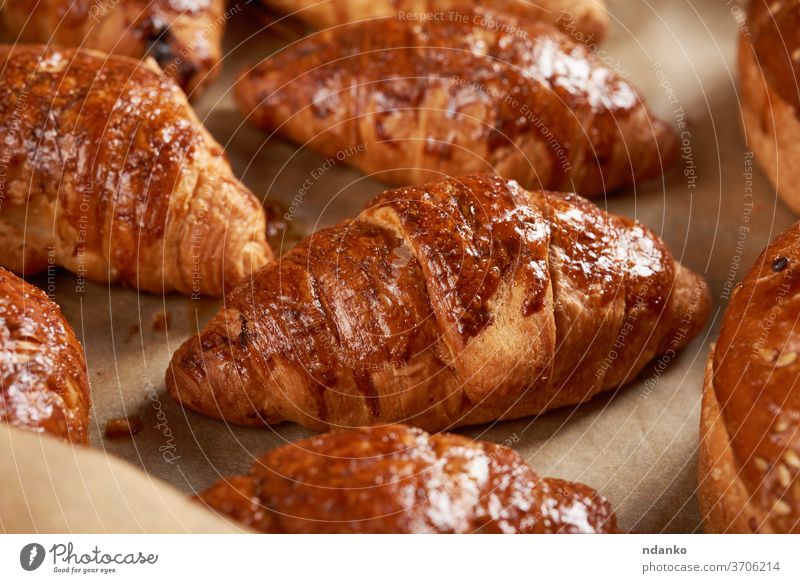gebackene Croissants in einem Backblech auf braunem Pergamentpapier, köstliches und appetitliches Gebäck Knusprig Kruste Küche Bäckerei Brot Frühstück Brötchen