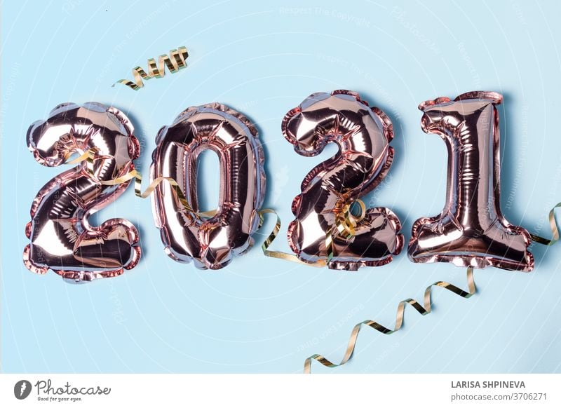 Gold-rosa Luftballons in Form von Nummern 2021 mit goldener Serpentine auf blauem Hintergrund. Ein frohes neues Jahr feiern. Flachgelegt, Draufsicht Vorabend