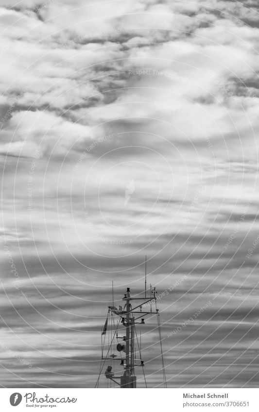 Mast eines Fischerbootes vor Wolkenhimmel an der Nordsee Schiff Boot Außenaufnahme Schwarzweißfoto Schwarz und weiß Schifffahrt Nordseeküste Hafen Kutter