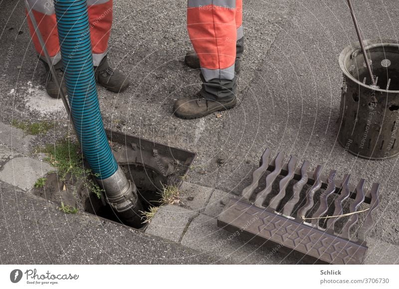 Arbeiter in Sicherheitskleidung reinigen Gully mit Absaugvorrichtung Kanalreinigung Reinigung Absaugen Schuhe Hosen Leuchtfarbe Straße Asphalt Gullydeckel