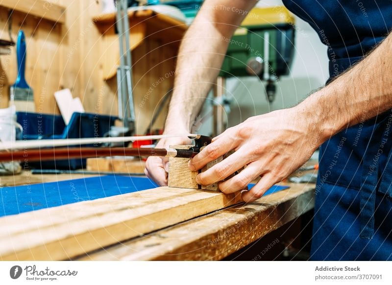 Geigenbauer restauriert Geigenbogen in der Werkstatt Zupfinstrumentenmacher Schleife Reparatur machen Kunstgewerbler Instrument wiederherstellen Mann Handwerk