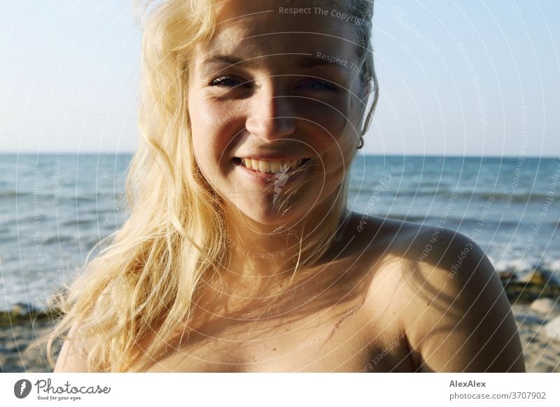 Portrait einer jungen, blonden Frau vor der Ostsee junge Frau Mädchen 18-20 Jahre schlank schön lockig sinnlich natürlich grüne Augen lange Haare langhaarig