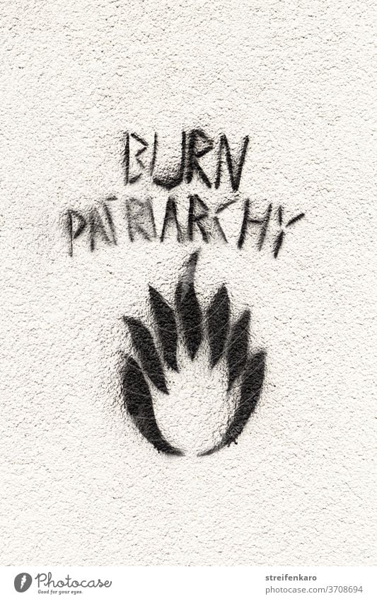 Graffiti "Burn Patriachy" weißer Hintergrund weiße Wand schwarz Patriarchat Sc Schriftzeichen Design Flamme Kritik Aussage Fassade Mauer Zeichen Meinung