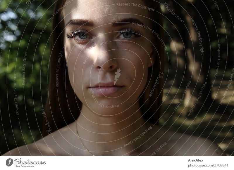 Nahes Portrait einer jungen Frau im Wald Licht sportlich feminin Gefühle emotional Blick in die Kamera Porträt Zentralperspektive Schwache Tiefenschärfe